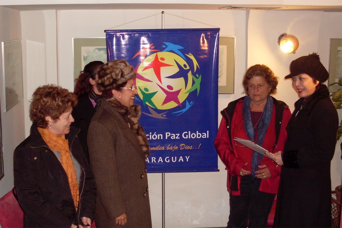 A group of people standing in front of a banner, expressing their intenciones.