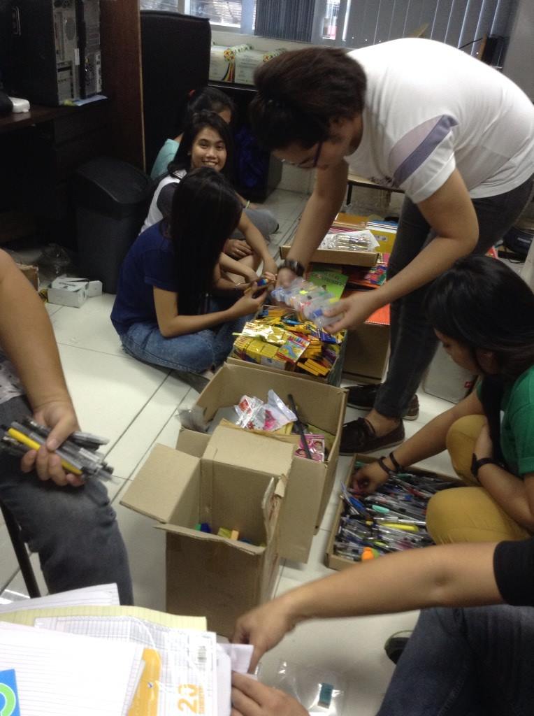 Volunteers organize and package school supplies.