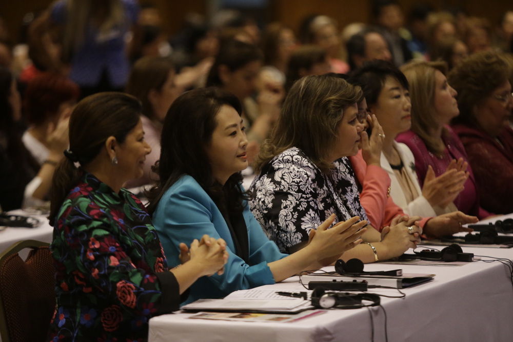 Attendees listening and clapping at Dr. Jun Sook Moon's conference event, themed 
