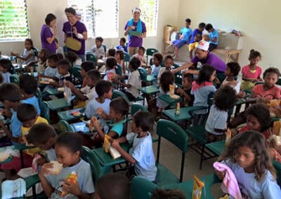 Global Peace Foundation Volunteers and children eat lunch together.