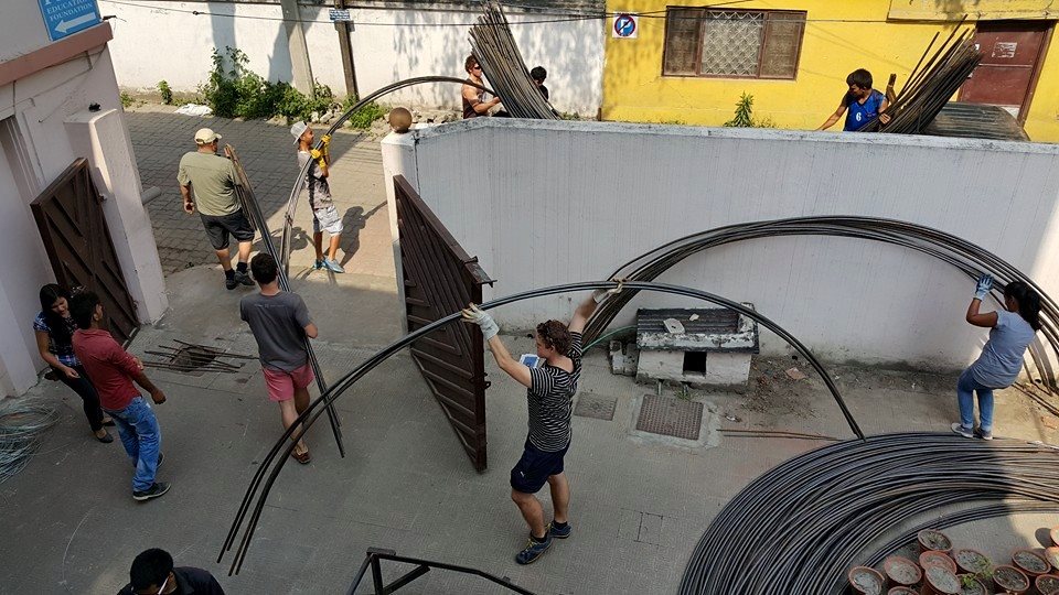 Global Peace Foundation Volunteers haul bent steel pipe.