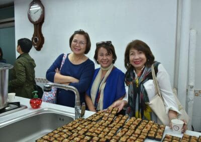 Women leaders pose in front sweets they have made