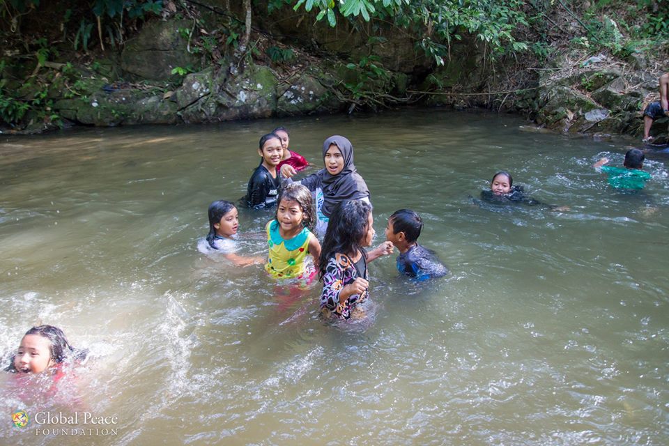 A group of children are swimming in a river.