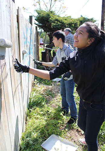 GPY high school volunteers paint over graffiti-covered fences