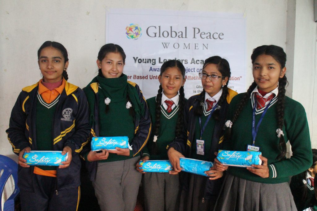 Girls hold sanitary pads handed out at leadership and women's health workshop