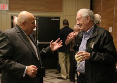 Two men engaged in conversation during a coffee break at a conference.