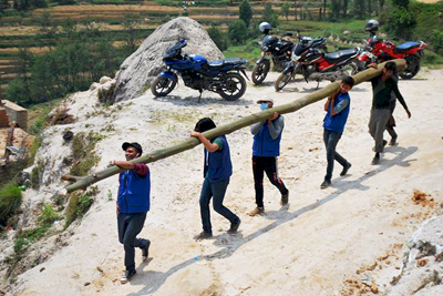 RiseNepal volunteers carry logs to rebuild communities in Nepal