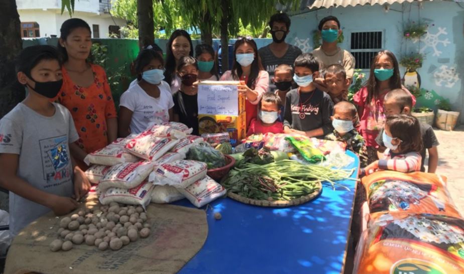 Families around donated food in Nepal