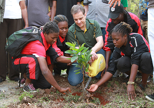 A group of people planting a tree.