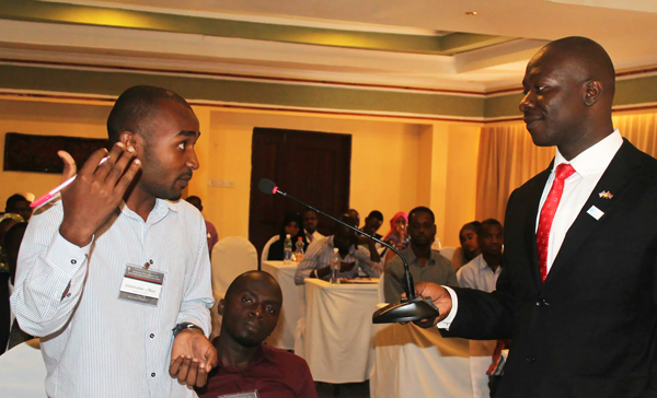 Youth participants engage in discussion with speakers at youth summit in Zanzibar.