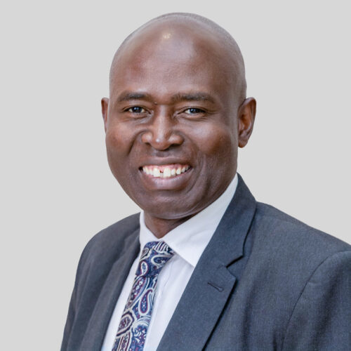 Mr. Daniel Juma Omondi, a man in a suit and tie, smiling.