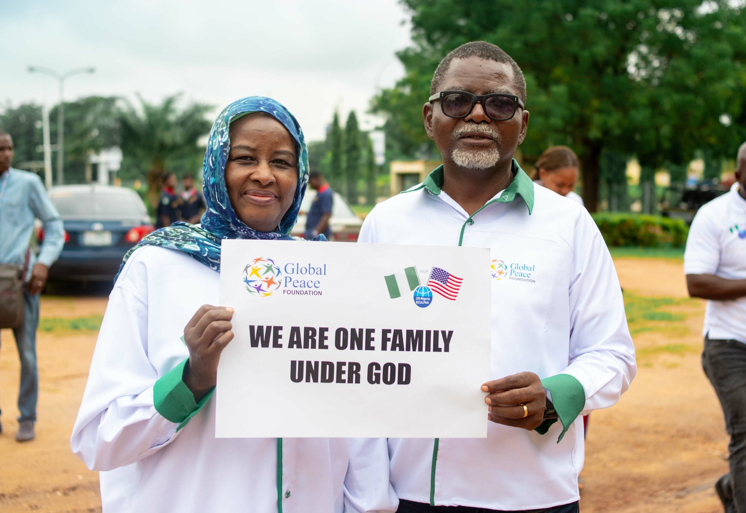 African people holding One Family under God sign