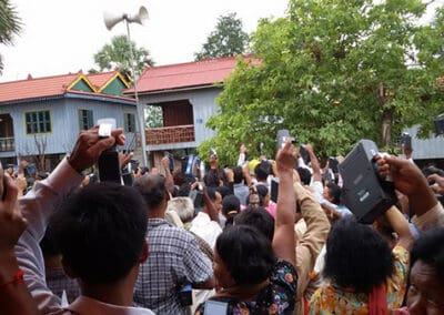 Villagers of Komgpong Speu Province hold up lamps at dusk.