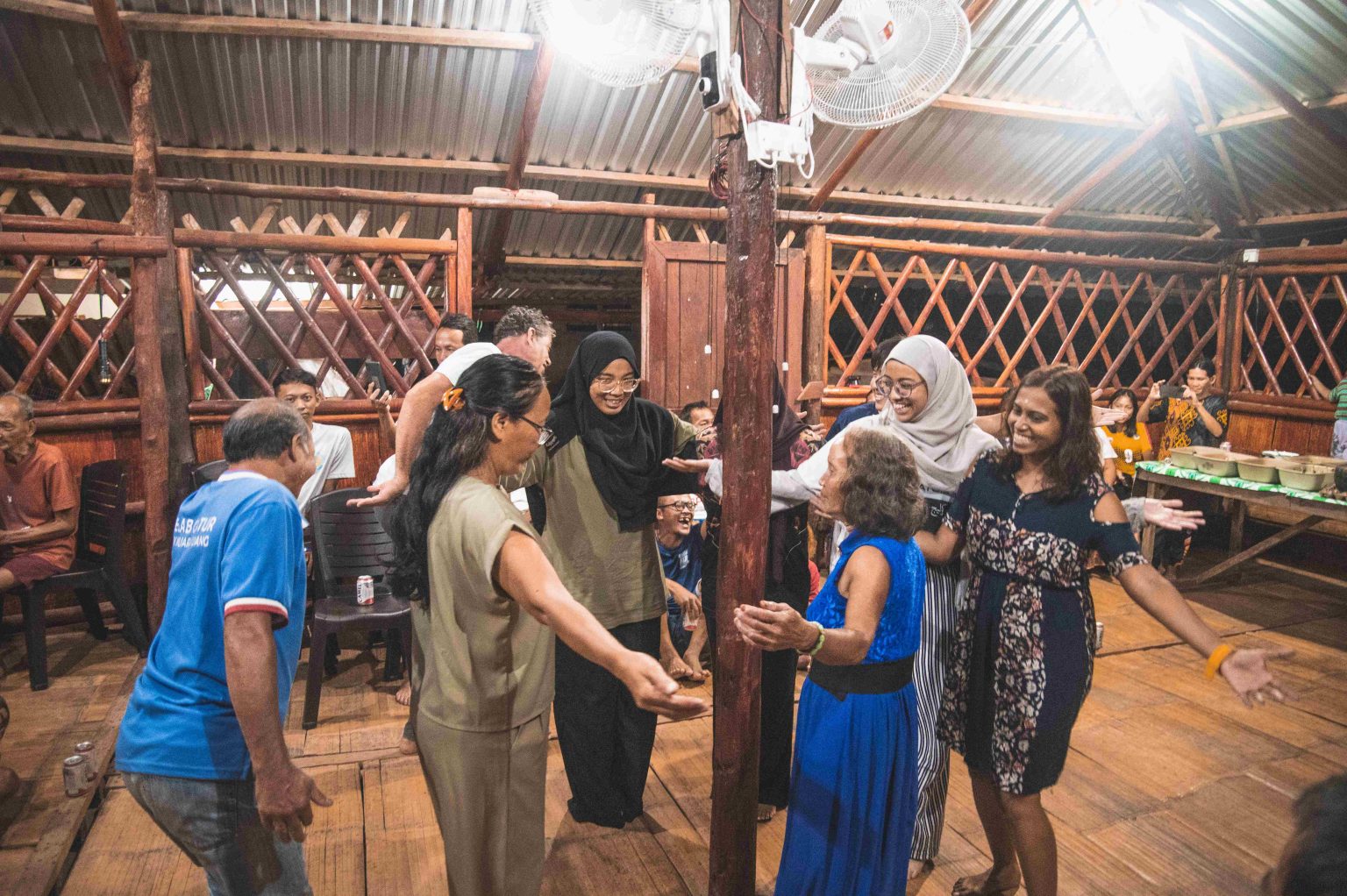 Villagers dancing with volunteers