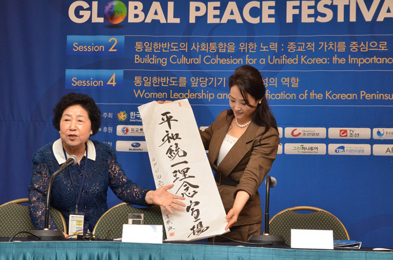 Mrs. Young Sook Kang and Dr. Jun Sook Moon present a special calligraphy that express words of peace for the occasion.