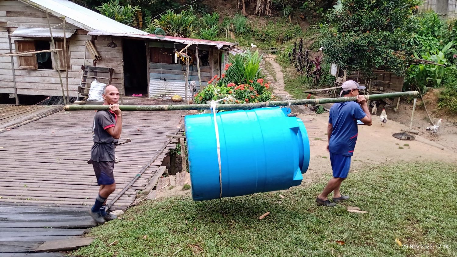 Villagers carrying piece of water supply system