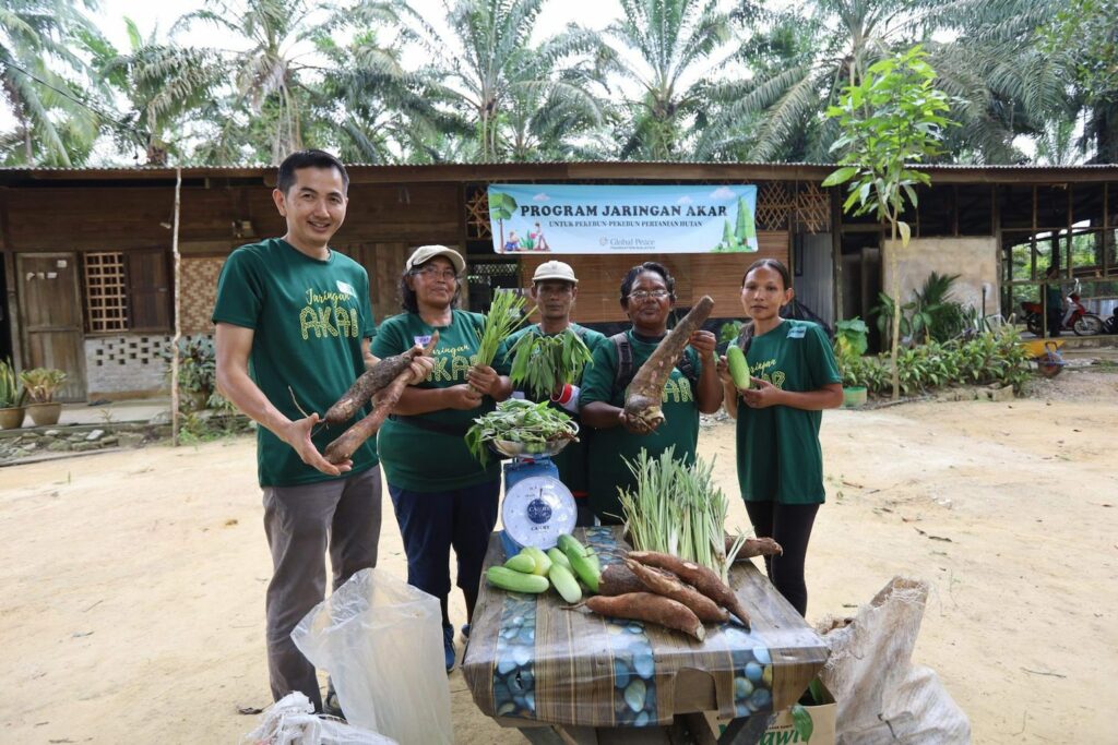 Orang Asli farmers holding their organic harvest