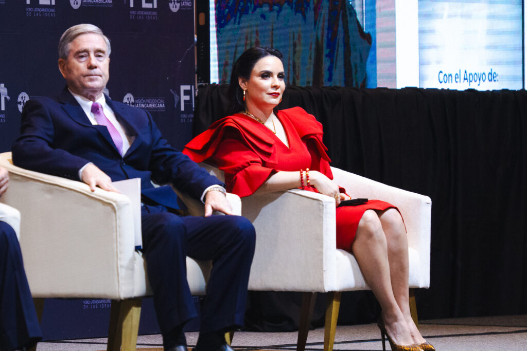 A man and a woman, dressed elegantly, engage in dialogue at the Latin American Forum of Ideas.