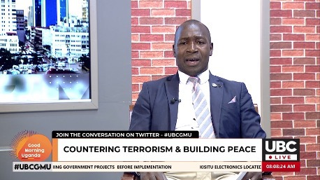 A man in a suit is advocating for peace and countering terrorism in the Uganda for Peace Campaign.
