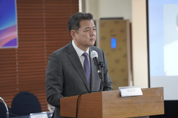 A man in a suit standing at a podium, supporting human rights in North Korea.