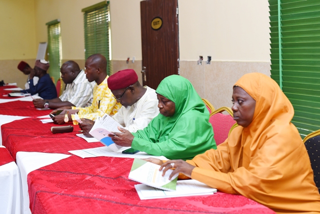 A group of people sitting at a long table discussing strengthening religious leaders and security operatives in Nigeria.