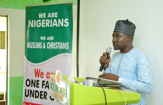 A man in a hat is speaking at a Peace Day Nigeria presentation.