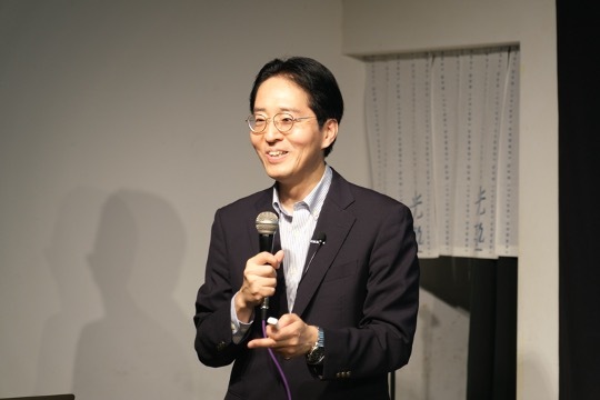 A man in a suit speaking into a microphone at the Peace Design Forum: Peacebuilding Together in Asia.