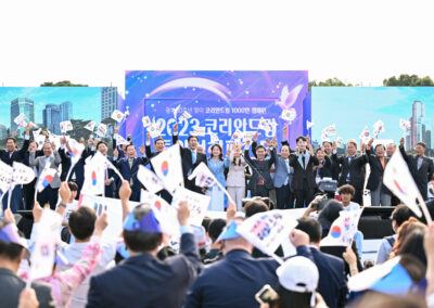 A group of people waving flags in front of a stage.