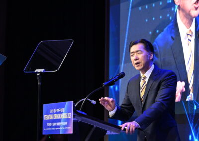 A man in a suit standing at a podium during the International Forum on One Korea 2023 held in Seoul, South Korea.