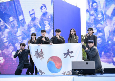 A group of people standing on stage with a korean flag.