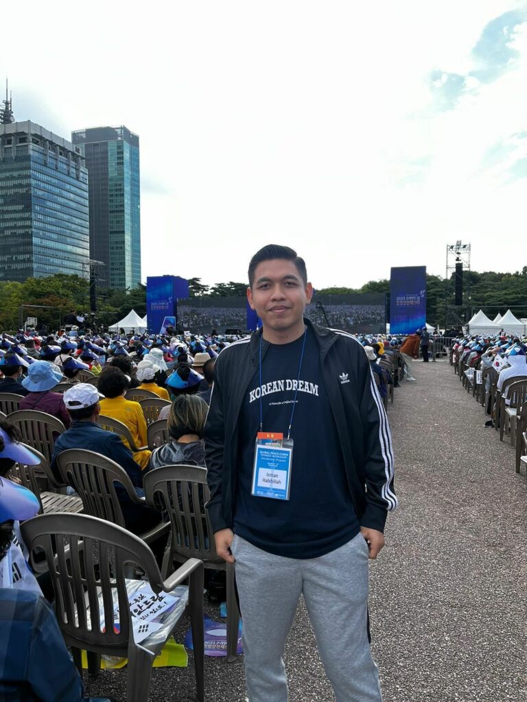 A man standing in front of a crowd of people, bridging boundaries as part of his journey with the Global Peace Foundation in Seoul.