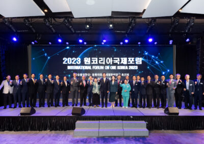 A group of people standing on stage at the International Forum on One Korea 2023 held in Seoul.