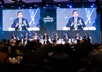 International Forum on One Korea 2023 Held in Seoul with a group of people sitting at a table in front of a large screen.