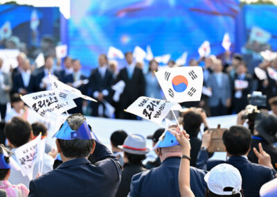 A crowd of people waving korean flags.
