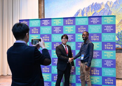 A man in a suit standing next to another man in a suit at the International Forum on One Korea 2023 held in Seoul, South Korea.