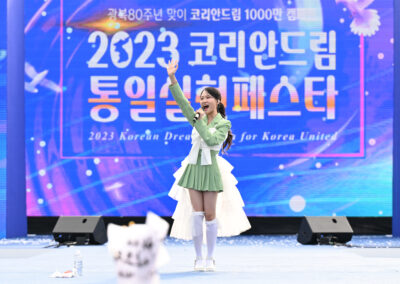 A girl in a green dress is standing on a stage.