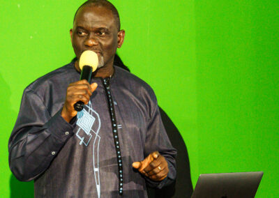 A man conducting community safety awareness trainings in front of a green screen.