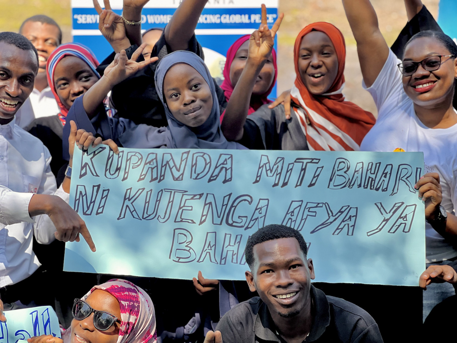 A group of people holding up a sign during Tanzania's celebration of International Day of Peace 2023.