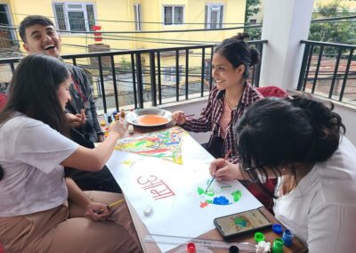 A group of people from Nepal sitting around a table playing with paint on the International Day of Peace.