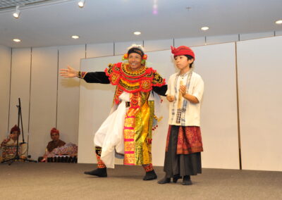 A couple dressed in traditional clothing showcasing their cultural heritage on a stage at the Multicultural Festival 2023.