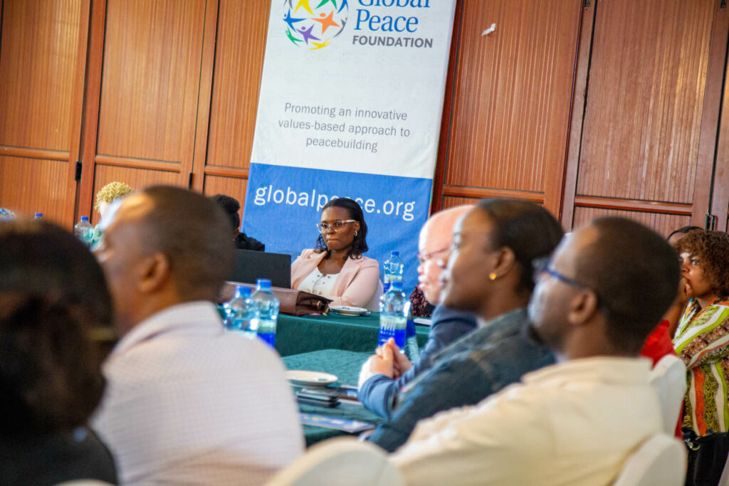 A group of people sitting at a table discussing the Safeguarding Civic Space in Tanzania, organized by the GPF.