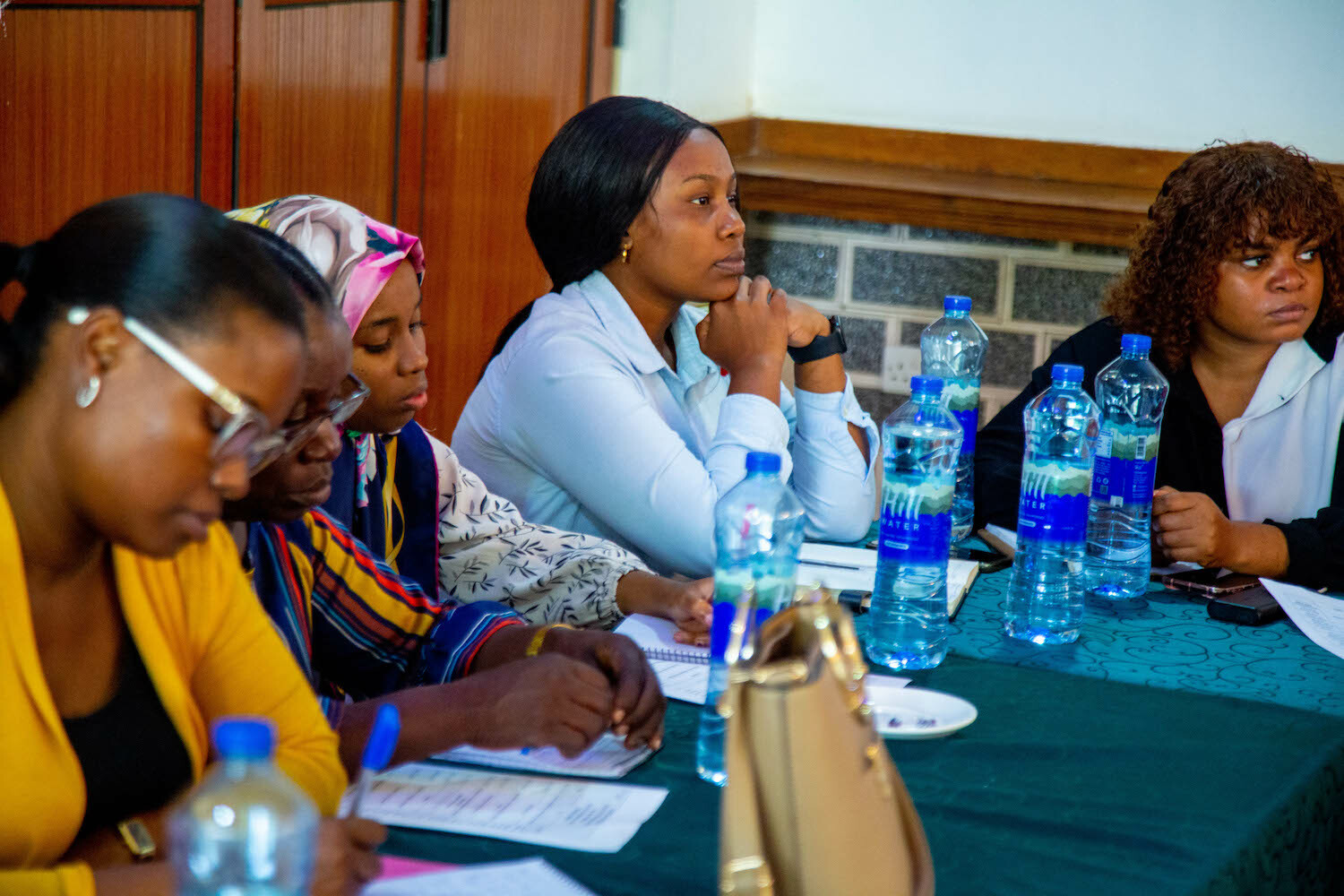 A group of women from GPF Tanzania sitting at a table with water bottles, engaged in Safeguarding Civic Space discussions.