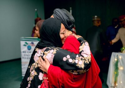 Two women hugging each other at a Deepening Democracy event in Nigeria.