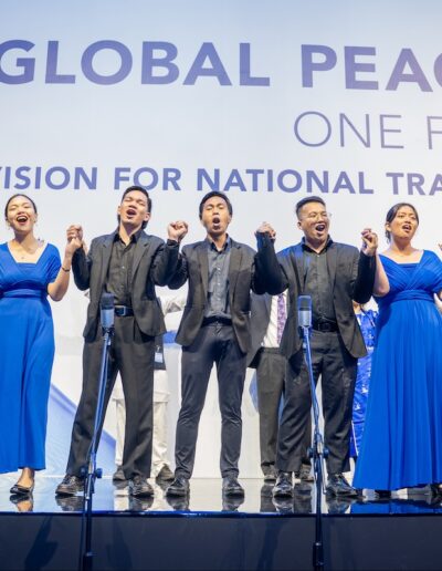 A group of people singing on stage at the Global Peace Convention.