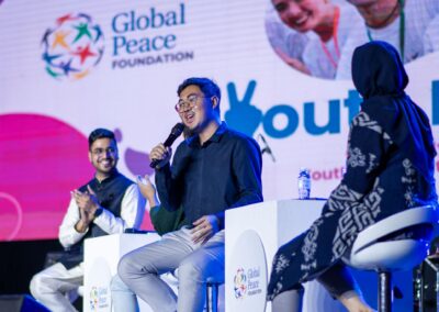 A group of people on stage at the global peace youth forum.