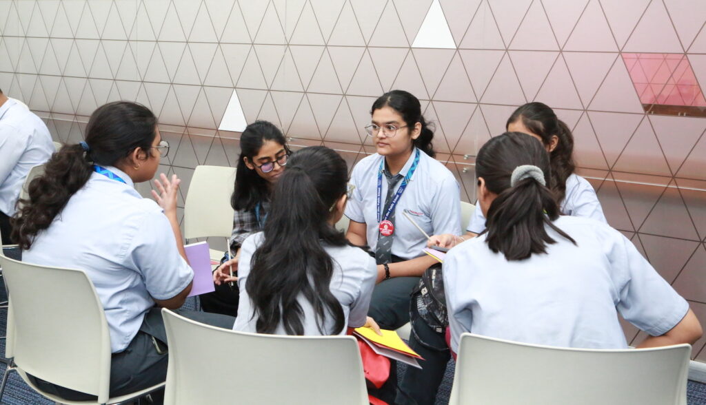 A group of Young Leaders engaged in a Youth Circle Dialogue for peacebuilding, sitting around a table.