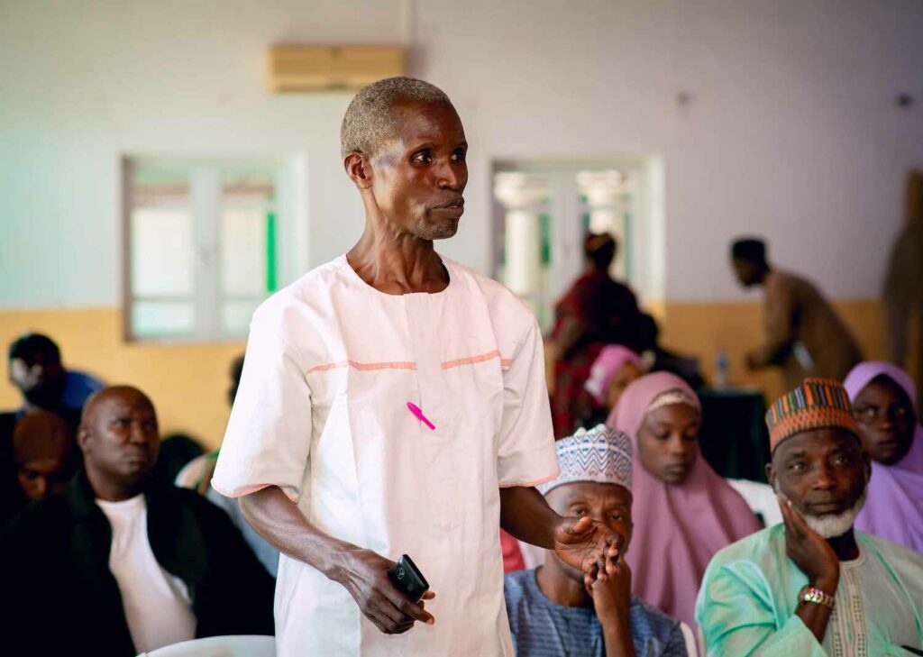 A man from Nigeria is standing in front of a group of people during a peacebuilding workshop.