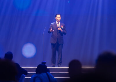 A man in a suit giving a speech on stage at the awards gala.