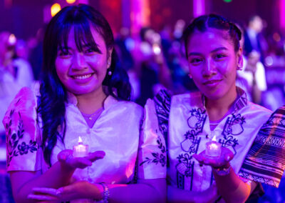 Two Asian women holding candles at a Global Peace Convention event.