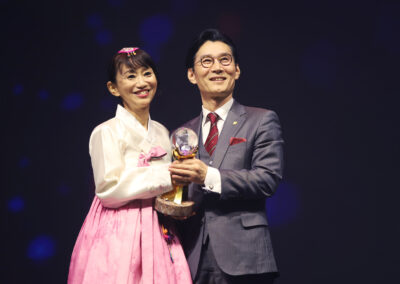 A man and woman holding an award at the awards gala.